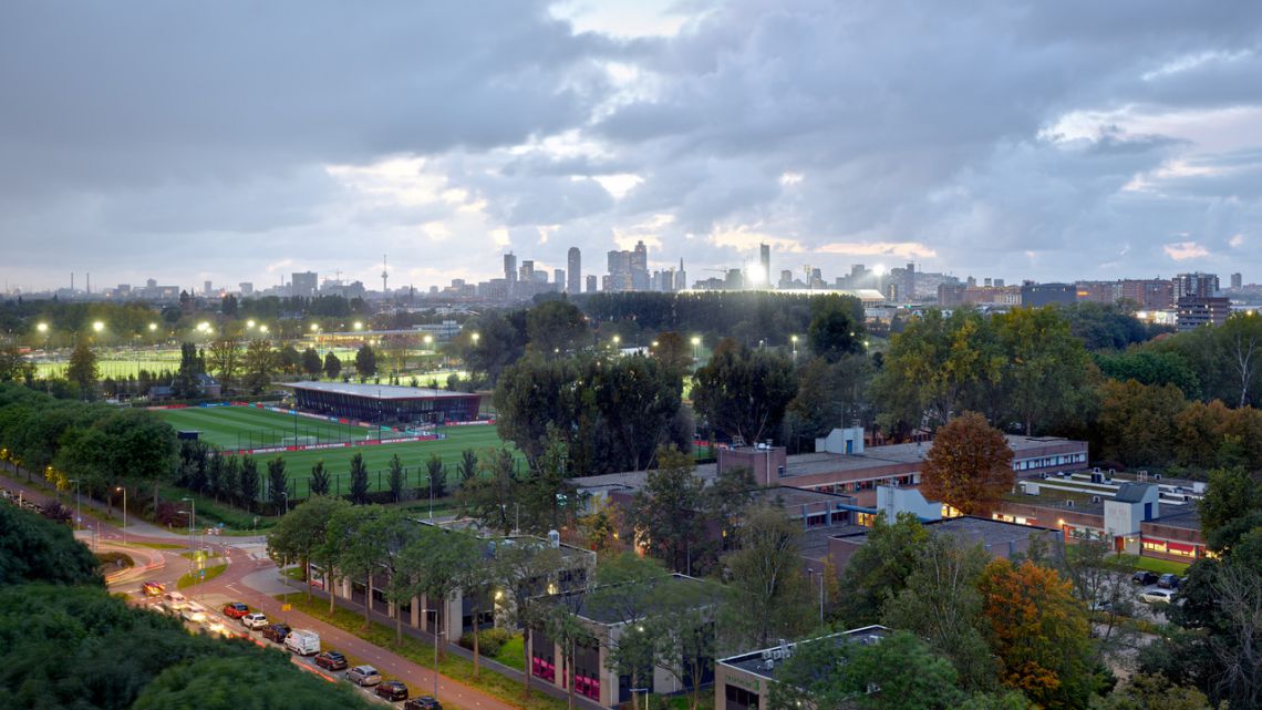 Bestaande sportvelden, bebouwing en groen op Sportcampus Rotterdam, met de skyline op de achtergrond